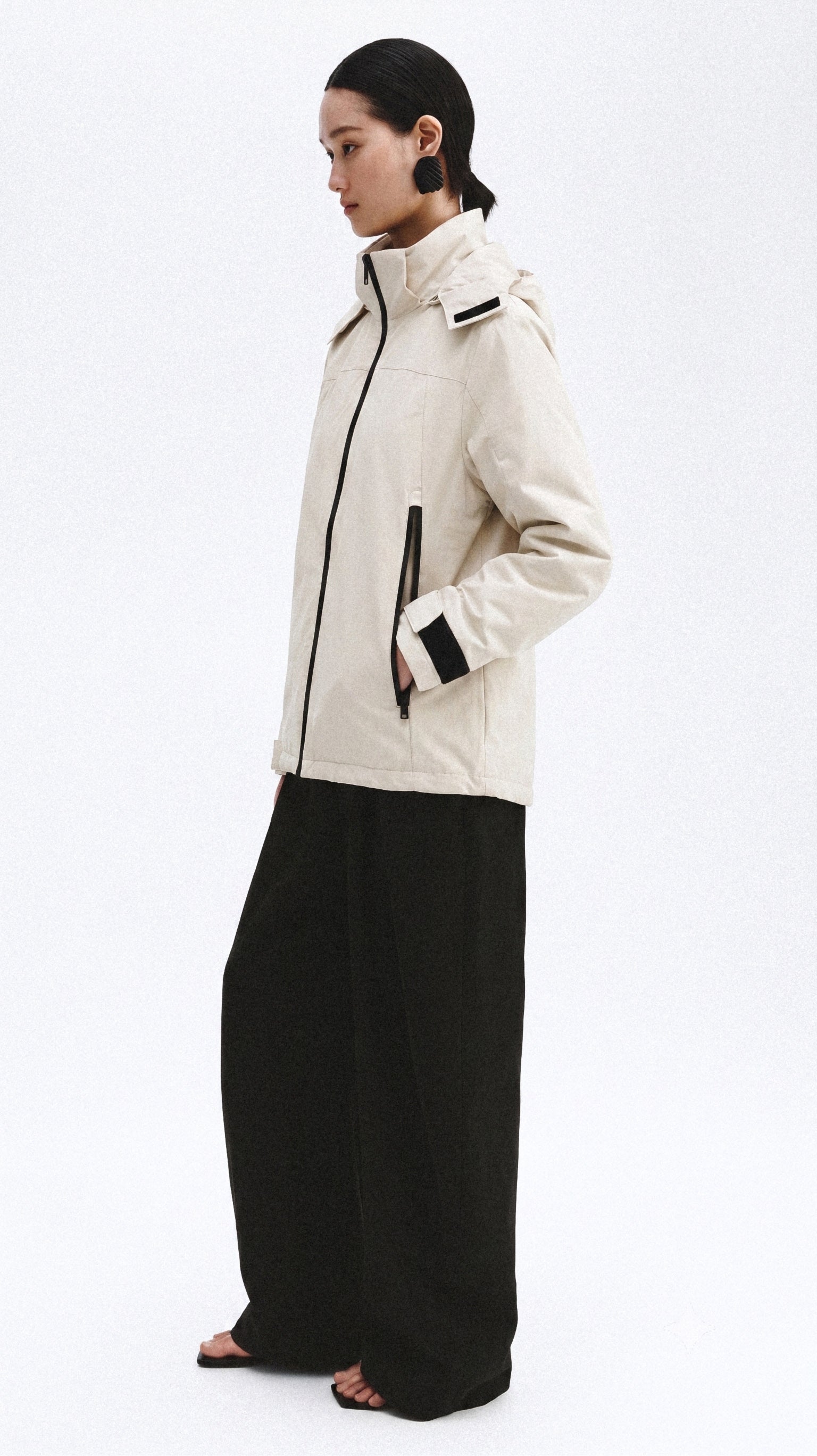 Modelo con chamarra rompevientos color Sand Cream de UMI wearclub, vista lateral